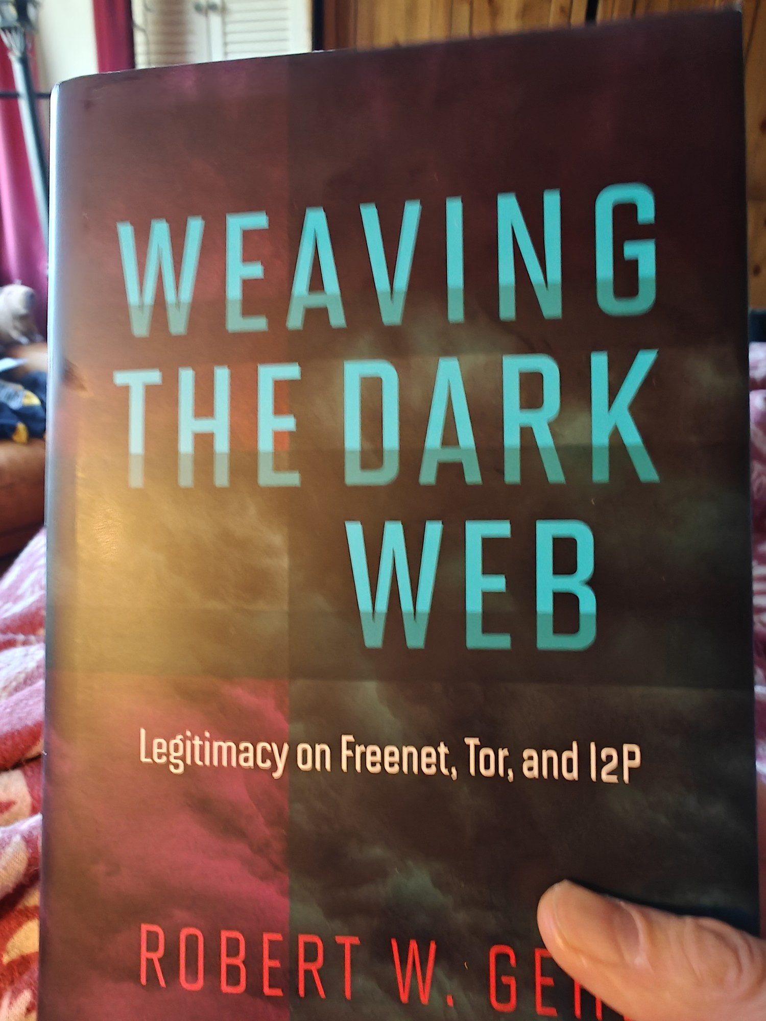 The cover of Robert W. Gehl's Weaving the Dark Web: Legitimacy on Freenet, Tor, and I2P. It features the main heading text in light blue above the subheading in light yellow and the author's name in red. This is overlayed on abstract squares of muted colours. 