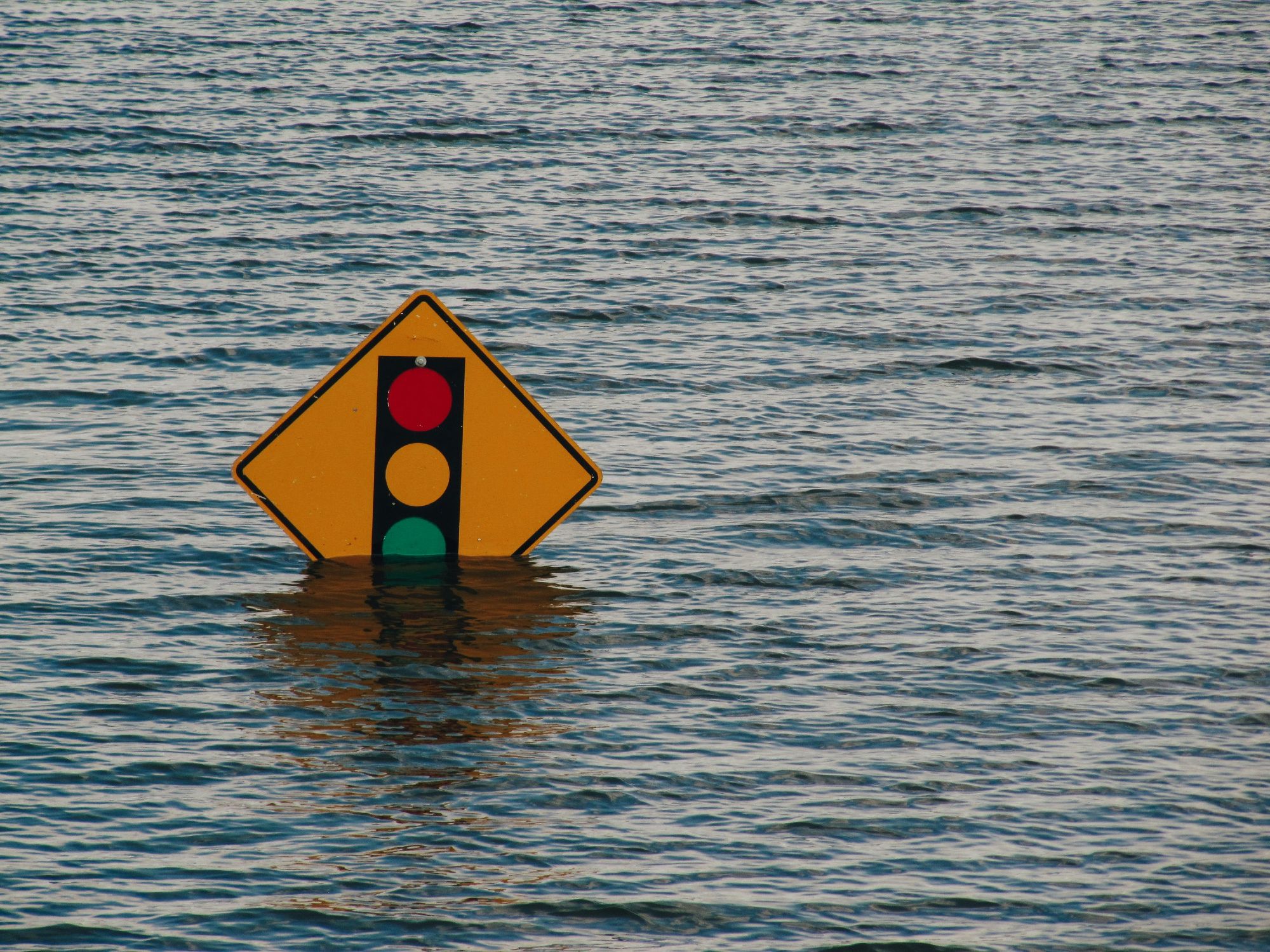 A photo of a signpost half underwater due to flooding