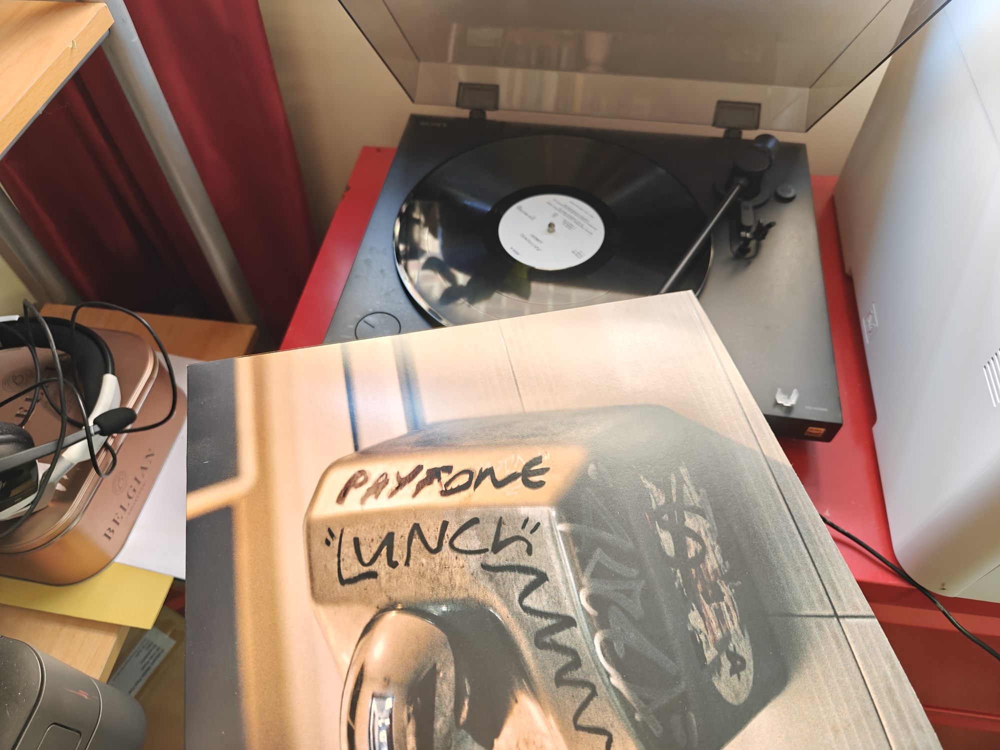 The cover of Payfone - Lunch which shows a rundown hairdryer. The vinyl record plays in the background 