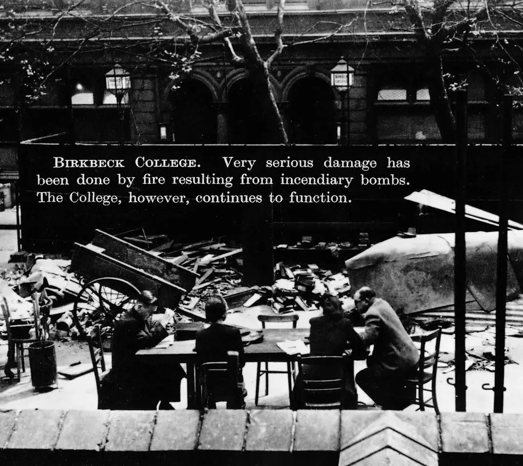 A picture of students and a teacher studying outside amid the wreckage from a WW2 bomb. 