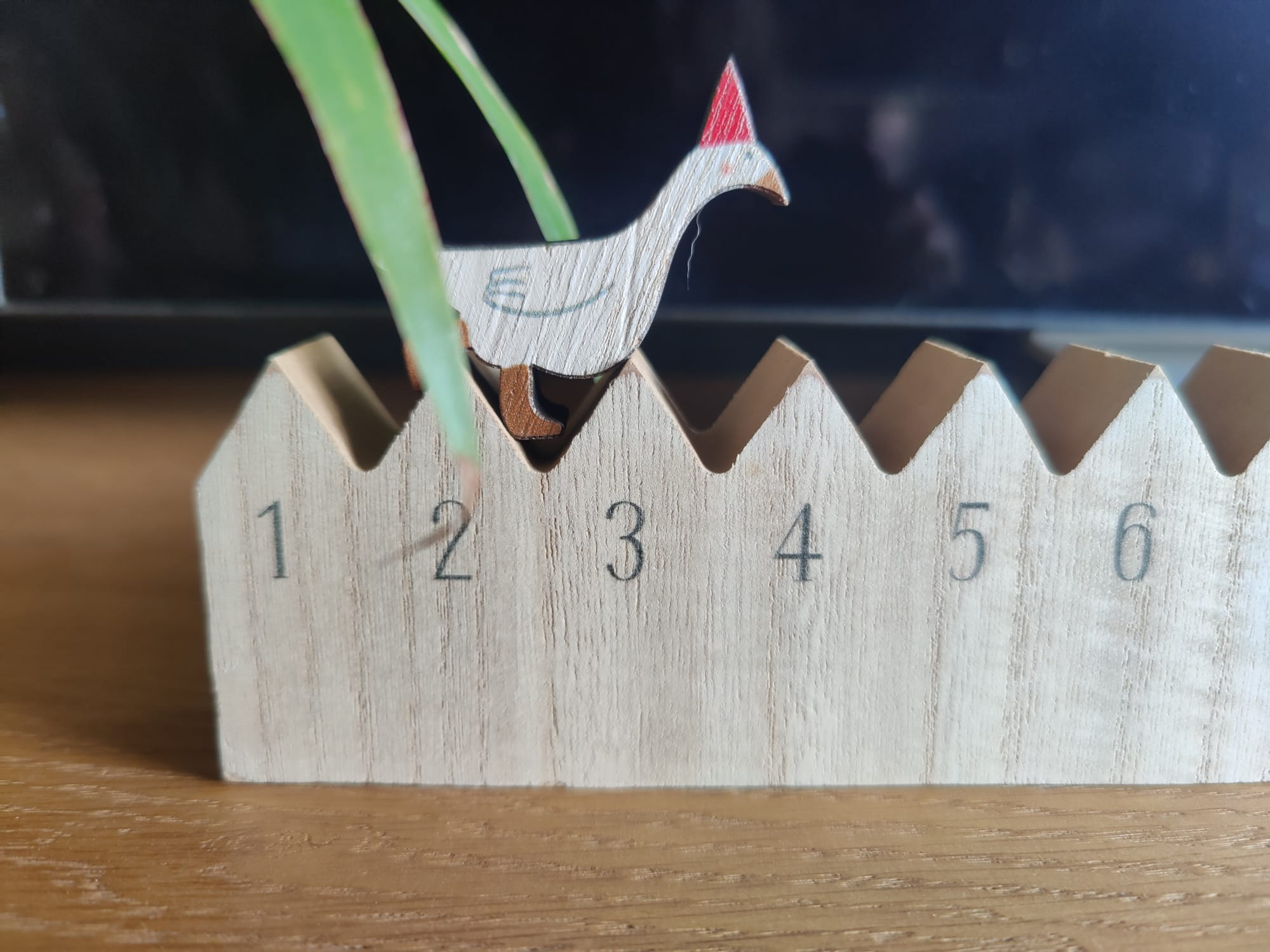 A wooden goose on top of a "calendar" (a series of numbers), in slot 2