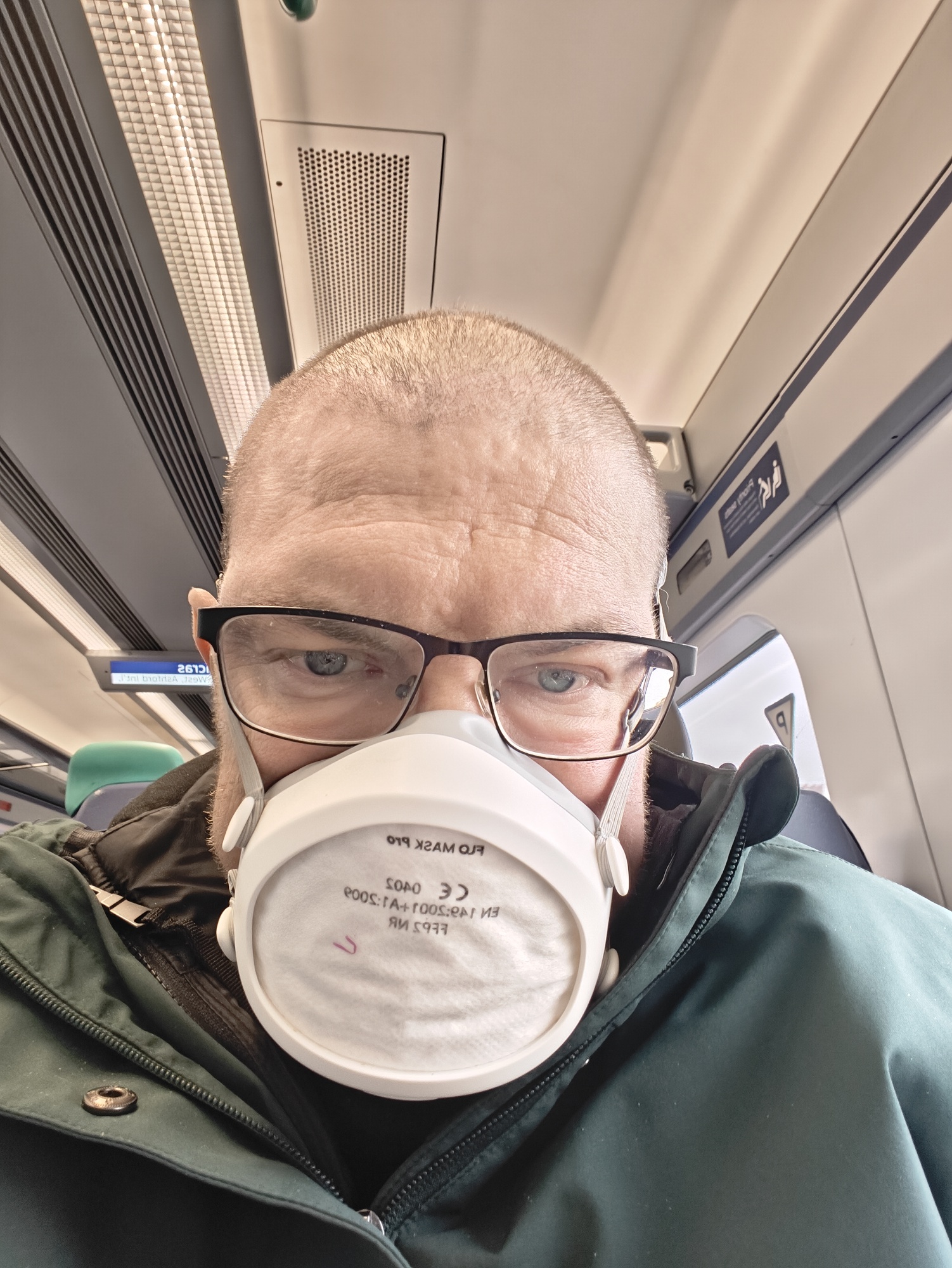 A picture of me on the train, wearing a face mask 