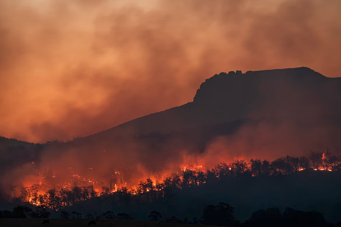 A desolate landscape of wildfires, all red and black and volcanic