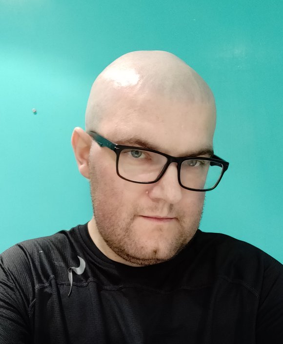 An informal headshot with a blue-green background